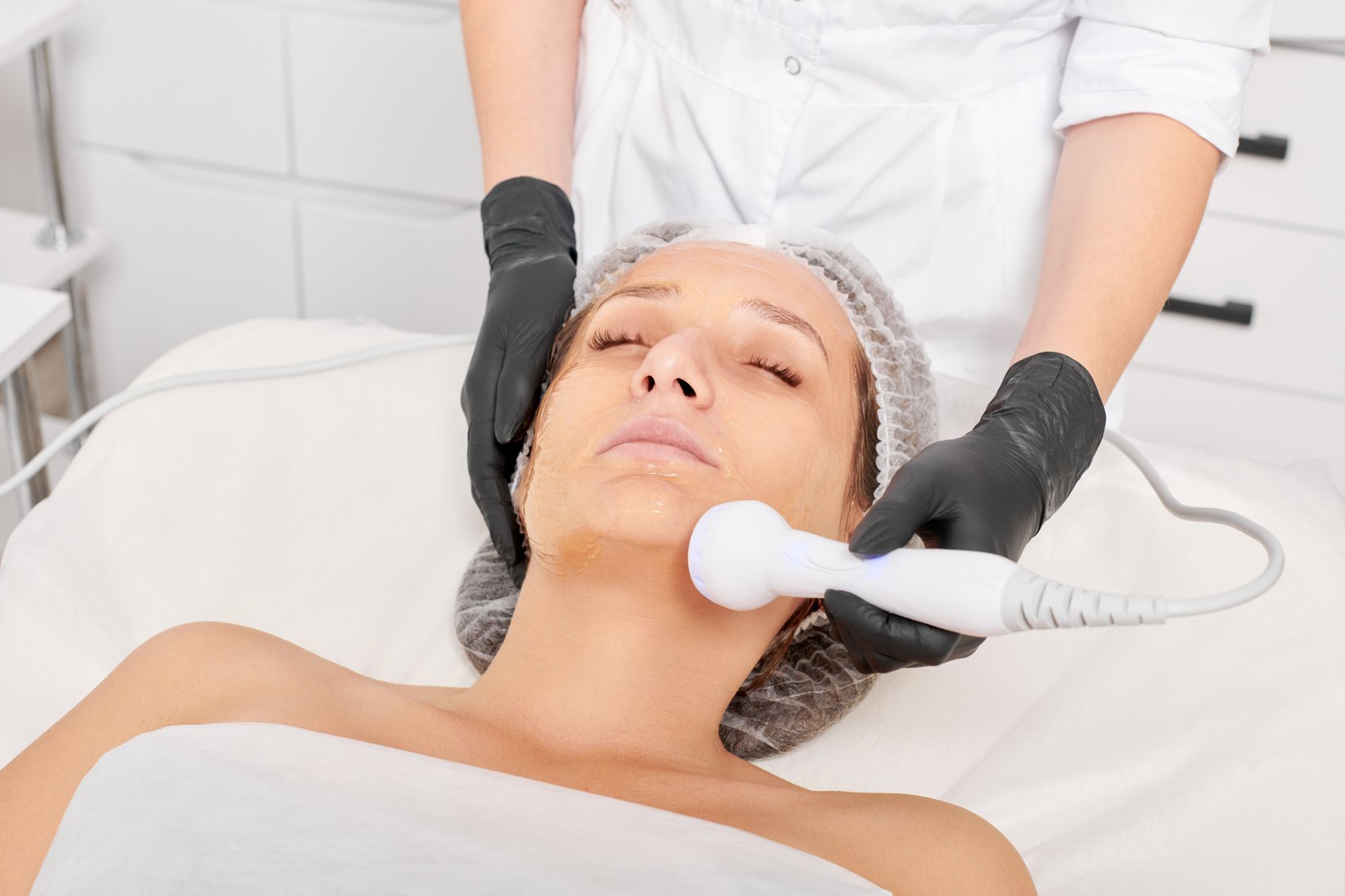 Cosmetologist makes RF lifting for rejuvenation woman face, anti aging cosmetic procedure